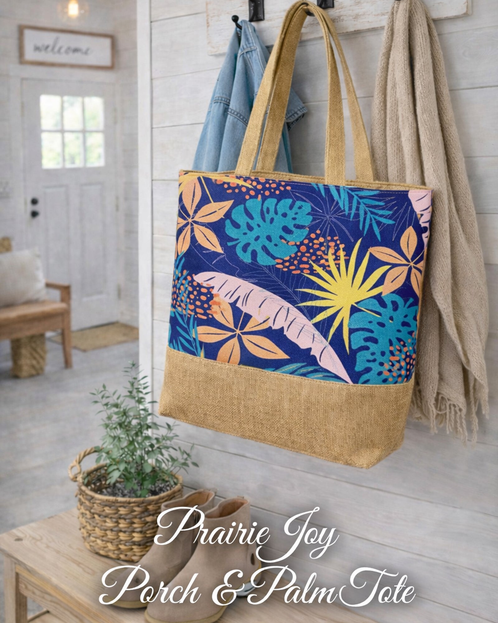 Prairiejoy Porch & Palm Tote Bag hanging in a farmhouse entryway with navy botanical print and natural base