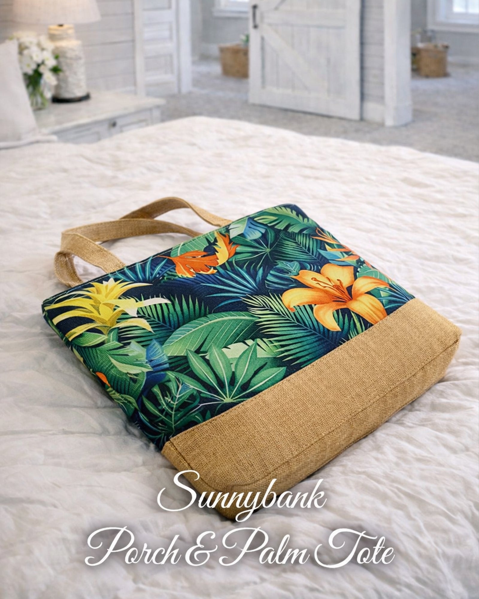 Sunnybank Porch & Palm Tote Bag lying flat on a bed showing tropical botanical print and natural base